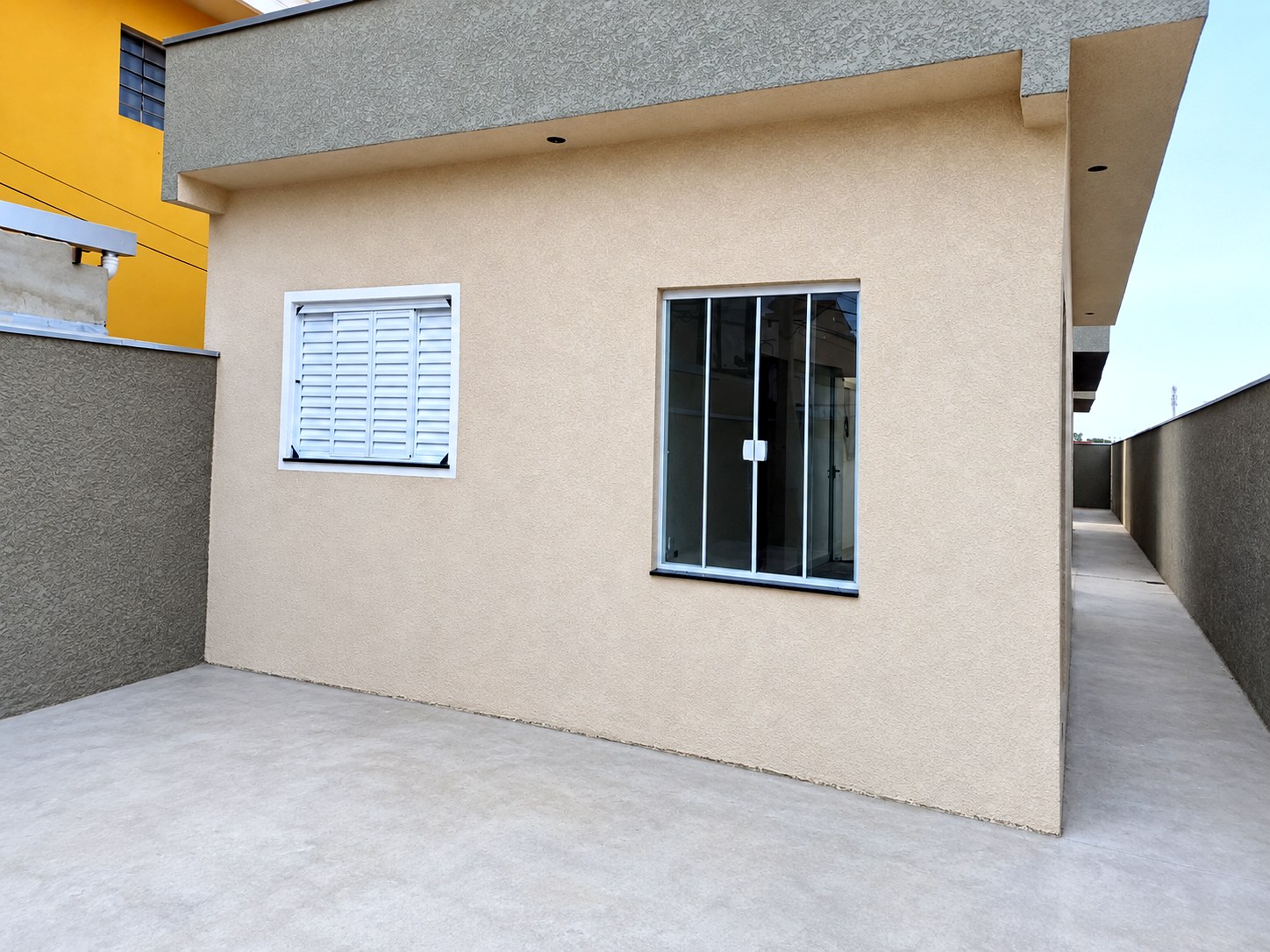 Lateral da casa e corredor de acesso